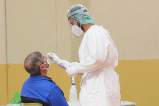 Archivo - Una sanitaria toma muestras a un hombre a través de un frotis de nariz durante la realización de test de antígenos a los vecinos de la localidad de Pedrajas de San Esteban, Valladolid, Ca