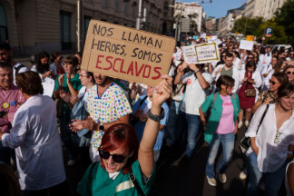 Archivo - Manifestante porta una pancarta que reza 'Nos llaman héroes, somos esclavos' durante la manifestación con motivo de la huelga de médicos contra el nuevo Estatuto Marco, frente al Congreso
