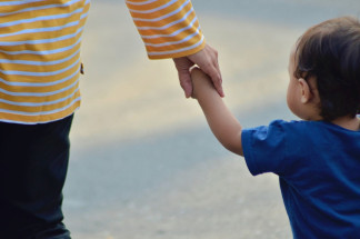 Archivo - Niño caminando con un adulto.