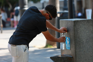Una persona se refresca en una fuente. A 05 de julio de 2026, en Sevilla (Andalucía, España). Andalucía se sitúa como la comunidad que registra las temperaturas más altas durante la segunda ola d
