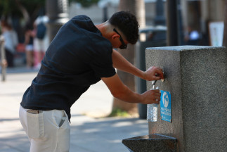 Una persona se refresca en una fuente. A 05 de julio de 2026, en Sevilla (Andalucía, España). Andalucía se sitúa como la comunidad que registra las temperaturas más altas durante la segunda ola d