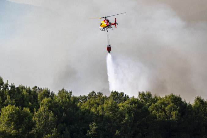 Helicóptero bombardero trabaja en las tareas de extinción del incendio en Pla de Manlleu, a 8 de julio de 2026, en Pla de Manlleu, Aiguamurcia, Tarragona, Catalunya (España). Los Bombers de la Gene