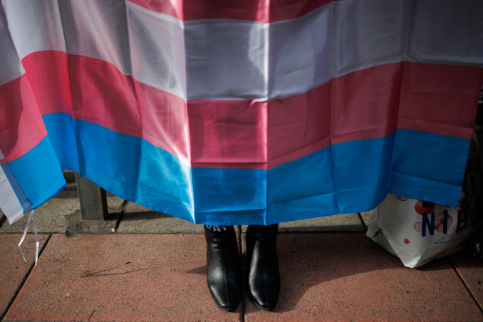 Archivo - Los zapatos de una mujer debajo de una bandera trans durante una concentración de la Federación Plataforma Trans, en la sede del PSOE en la calle Ferraz, a 28 de octubre de 2022, en Madrid
