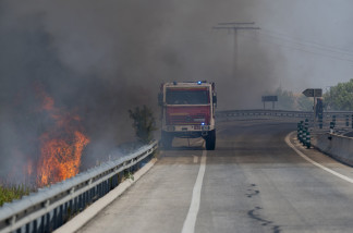 Un camión de bomberos durante las labores de extinción de un incendio forestal, en la carretera M 206 entre Torrejón y Loeches, a 23 de julio de 2026, en Madrid (España). La circulación de alta v
