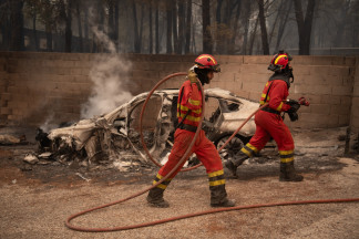 Personal de la UME apagando fuegos en viviendas y naves en Piedralaves, durante el incendio de Burgohondo, a 26 de julio de 2026, en Piedralaves, Ávila, Castilla y León (España). El teniente corone