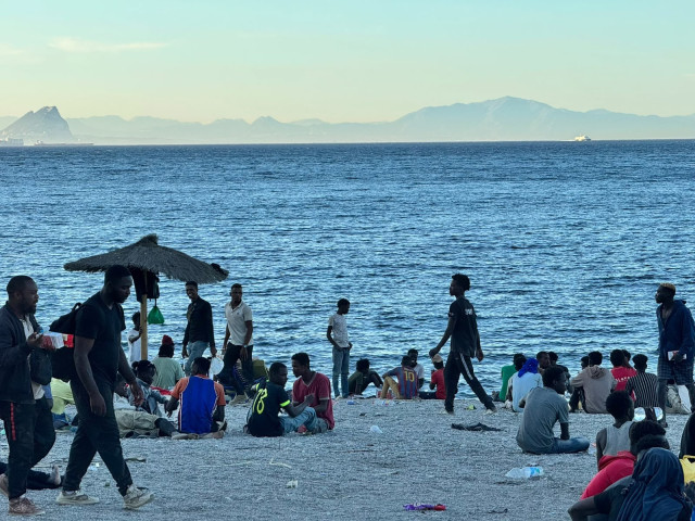 Varios migrantes en la playa del Trampolín, a 3 de agosto de 2026, en Ceuta (España). La ONG ceutí Luna Blanca ha repartido en los últimos días más de 12.000 comidas entre las personas migrantes que accedieron a la ciudad durante la entrada masiva desde M