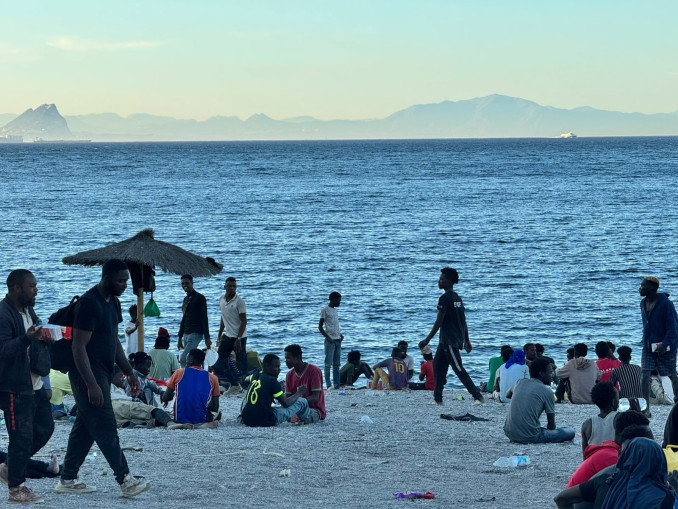 Varios migrantes en la playa del Trampolín, a 3 de agosto de 2026, en Ceuta (España). La ONG ceutí Luna Blanca ha repartido en los últimos días más de 12.000 comidas entre las personas migrantes