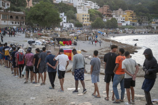 Varios inmigrantes en una playa, a 19 de agosto de 2026, en Ceuta (España). Ceuta sigue afrontando una grave crisis humanitaria después de la histórica entrada masiva de más de 70.000 migrantes a 