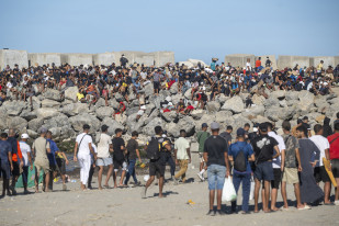 Miembros de la Cruz Roja reparten comida a los inmigrantes en una playa, a 21 de agosto de 2026, en Ceuta (España). Ceuta sigue afrontando una grave crisis humanitaria después de la histórica entra