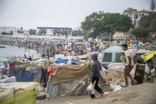 Varios inmigrantes acampados en la playa, a 5 de septiembre de 2026, en Ceuta (España). El Gobierno asume el control del puerto de Ceuta para la 'atención humanitaria' de personas migrantes en carpa
