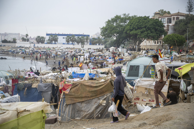 Varios inmigrantes acampados en la playa, a 5 de septiembre de 2026, en Ceuta (España). El Gobierno asume el control del puerto de Ceuta para la 'atención humanitaria' de personas migrantes en carpa