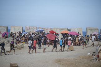 Varios migrantes acampados en la playa del Trampolín, a 23 de septiembre de 2026, en Ceuta (España). Embarcaciones de Salvamento Marítimo han trabajado este miércoles en la reparación de desperfe