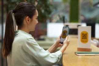 Archivo - Mujer escaneando un código QR de un restaurante.