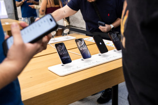 Varias personas ven los nuevo modelos de iPhone en la tienda de Apple de la Puerta del Sol