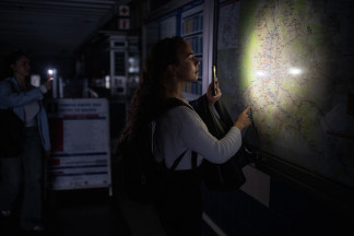 Archivo - Una mujer ilumina con la linterna del móvil un plano de la red de Metro de Madrid en una estación, el 28 de abril de 2025 en Madrid, España.  Alejandro Martínez Vélez / Europa Press 28/
