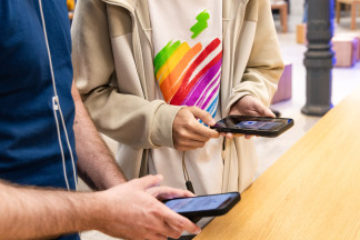 Varias personas ven los nuevo modelos de iPhone en la tienda de Apple de la Puerta del Sol