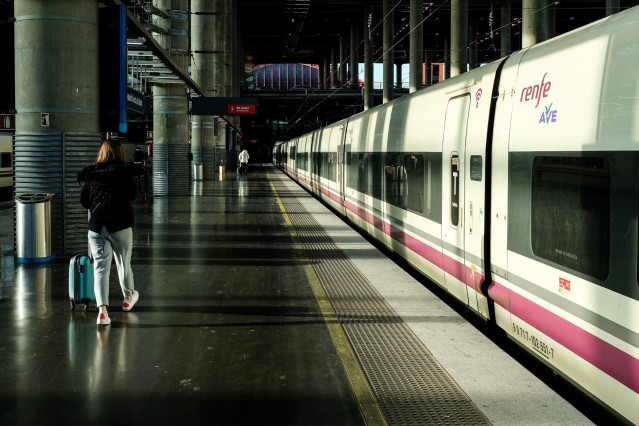 Archivo -  Una mujer camina por el andén junto a un tren de AVE de Renfe estacionado en las vías de la Estación de Atocha.